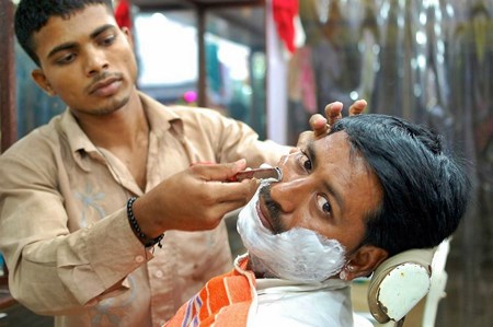 Man getting a shave with an open blade